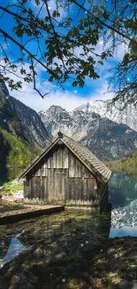 Tranquil mountain lake with a rustic cabin.