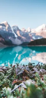 Mountain landscape with turquoise lake and snowy peaks.