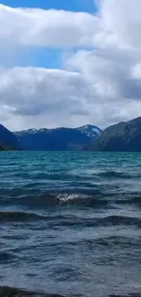 A serene mountain lake with cloudy sky.