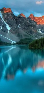 Mountain lake reflecting peaks at sunset.