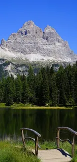 Serene lake with mountain and forest background.