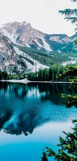 Serene mountain lake with reflection and snow-capped peaks.