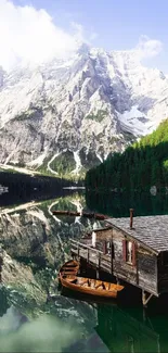 Serene mountain lake with cabin and boats reflecting nature's beauty.