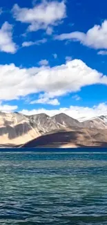 Tranquil mountain lake with blue skies and clouds.