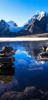 Serene mountain lake with reflections and snowy peaks.