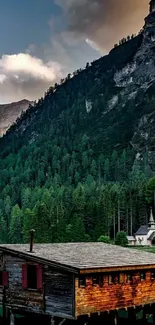 Serene mountain lake with cabin and forest.