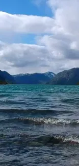 Scenic mountain lake with blue water and cloudy sky.