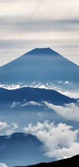 A serene mountain scene with blue sky and clouds for mobile wallpaper.