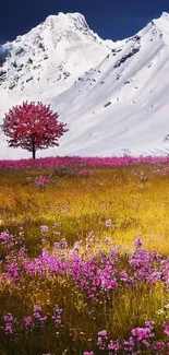 Vibrant tree by majestic snowy mountains in a colorful flowery meadow.