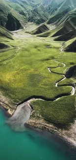 Aerial view of lush green valleys and a serene lake in a mountain landscape.