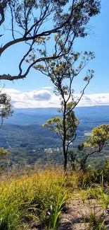 Serene view of mountains and trees under a blue sky.