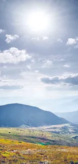 Serene mountain landscape with blue sky and sun.