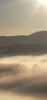 Mist over mountains with sun rays creating a serene atmosphere.