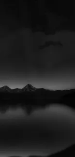 Dark serene mountain nightscape with reflections on a calm lake.