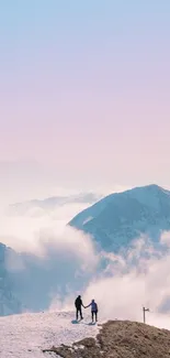 Two people standing on a snowy mountain peak with a pink and blue cloudy sky.