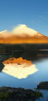 Mountain reflecting in calm lake under blue sky.