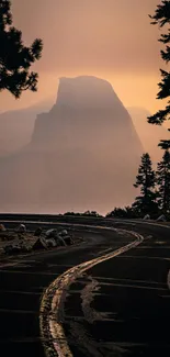 Misty mountain and winding road at sunset, creating a serene and tranquil scene.