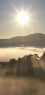 Sunrise over misty mountains with light rays creating a serene landscape.