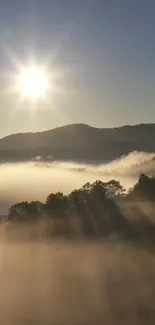 Serene mountain sunrise with mist and sun rays over hills.