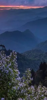 Serene mountain view at sunset with lush greenery and colorful sky.