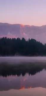 Serene sunset over mountains with lake reflections and misty atmosphere.