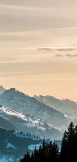 Snow-capped mountains at sunset with pastel orange sky.