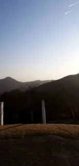 Serene sunset over rolling mountains under a clear sky.