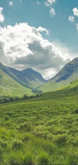 Lush green valley with mountains under a cloudy sky.