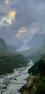 Serene mountain valley with misty clouds and a flowing river.