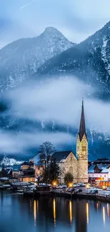 Serene village by a lake with snowy mountains.