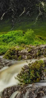 Serene mountain waterfall with lush greenery and rocky terrain.