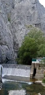 Serene mountain waterfall with lush trees and rocky cliffs.