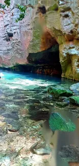 A serene cave pool with turquoise water and green rocks.
