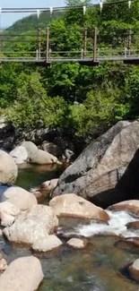 Serene river scene with rocks and a bridge surrounded by lush greenery.