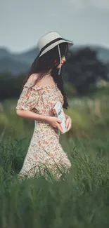 A woman in a floral dress walks through a lush green field in nature.