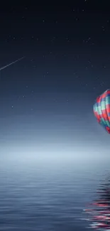 Hot air balloon floats over water under a starry night sky.