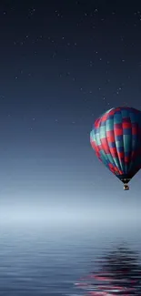 Starry night with balloon over reflective water, serene mobile wallpaper.