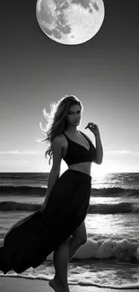 Woman by moonlit ocean under large moonlight in black and white.