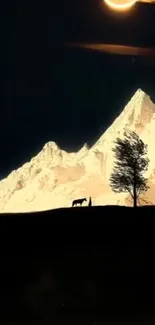 Peaceful night scene with mountains and tree silhouette.