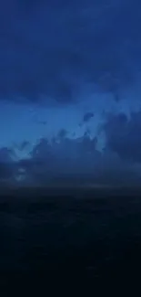 Serene ocean view at night with deep blue skies and stars.