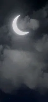 Crescent moon surrounded by soft clouds in a serene night sky.