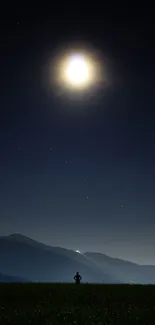 Silhouette under full moon in a serene night sky over mountains.