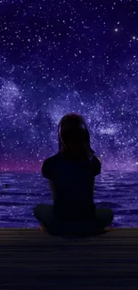 Person sitting by a sea under a starry night sky.