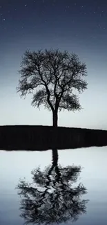 A solitary tree reflected in calm water under a starry night sky.