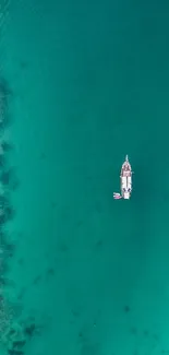 Aerial view of a boat in turquoise ocean waters.