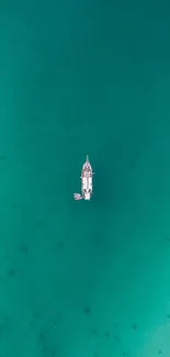 Aerial view of a boat in turquoise ocean waters.
