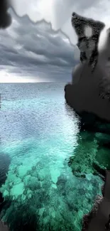 Turquoise waters meet dark cliffs under a stormy sky.