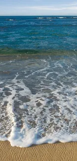 Ocean waves gently crashing on a sandy beach.