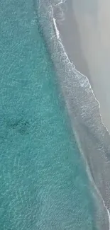 Serene aerial view of ocean waves and sandy beach for mobile wallpaper.