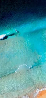 Aerial view of ocean waves with vibrant turquoise and sandy beach.